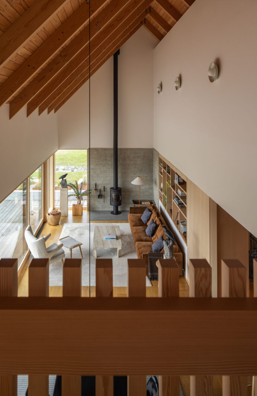 Dyes Inlet House — Nhìn từ gác lửng xuống, lan can gỗ thoáng.
