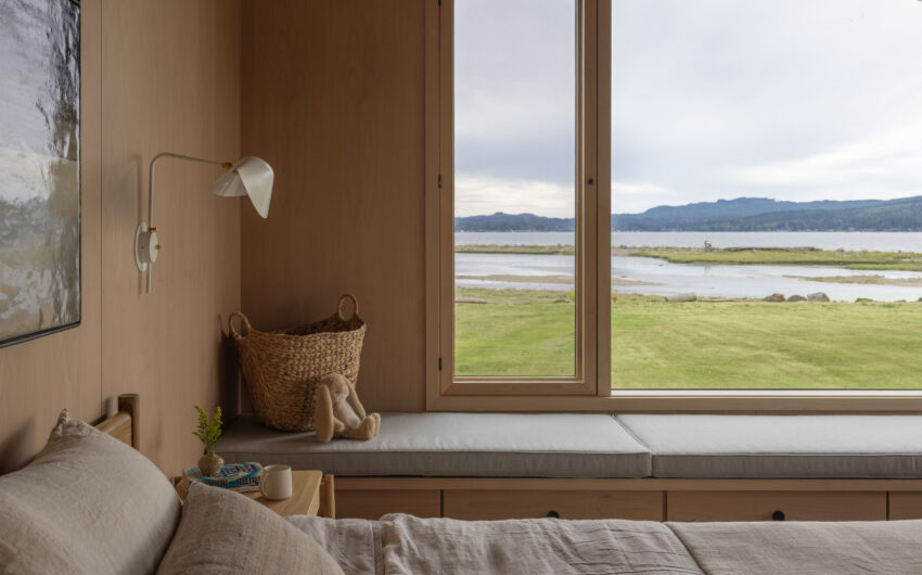 Dyes Inlet House — Góc ngồi bên cửa sổ ngập ánh sáng, hướng ra đầm nước.