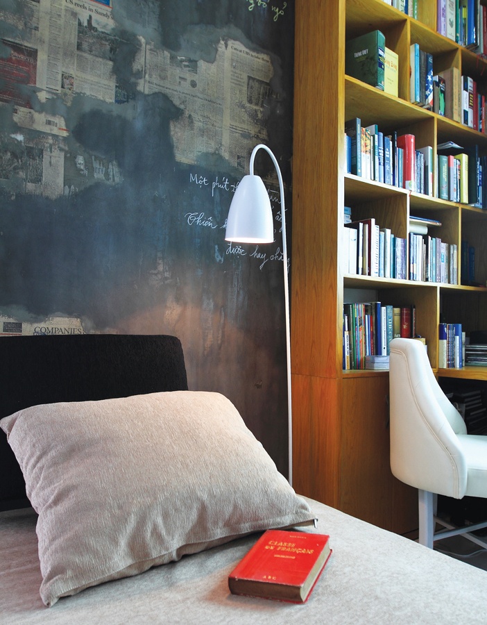 Thư phòng tại nhà với kệ sách, ghế thư giãn và ánh sáng chan hòa để cân bằng âm dương tốt hơn