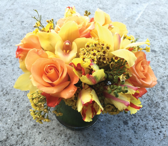 Sự kết hợp của tulip đỏ két, hoa lan cymbidium vàng, hoa hồng vàng - cam và hoa sáp (wax flower) vàng