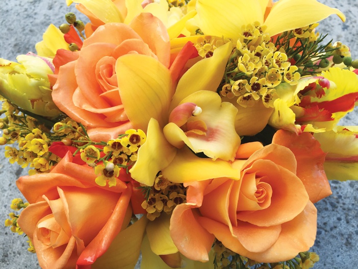 Sự kết hợp của tulip đỏ két, hoa lan cymbidium vàng, hoa hồng vàng - cam và hoa sáp (wax flower) vàng