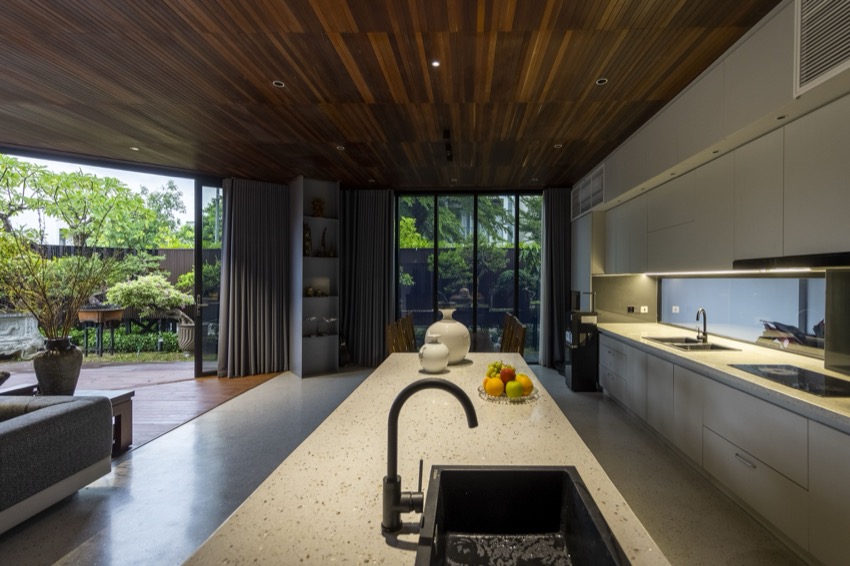 Đảo bếp bằng đá terrazzo, phía sau là mảng xanh sân trong