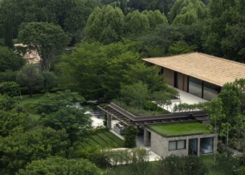Nhìn từ trên cao, nhà mái ngói dài nằm lọt giữa tán rừng ở Jardim GMM