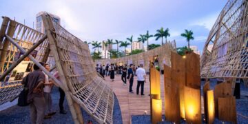 Lễ vinh danh Top 10 Awards 2025 và Khai mạc Pavilion “Dong buồm” Chiều ngày 22/5/2026, Bảo tàng Hà Nội trở thành điểm hẹn của giới kiến trúc và thiết kế khi Lễ vinh danh Top 10 Awards 2025 cùng triển lãm Pavilion “Dong buồm” chính thức khai mạc. Sự kiện thu hút đông đảo kiến trúc sư, chuyên gia, doanh nghiệp và cộng đồng yêu kiến trúc trên cả nước. Không chỉ là lễ trao giải thường niên, Top 10 Awards 2025 còn mở ra một không gian trải nghiệm sáng tạo. Tại đây, công chúng có cơ hội tiếp cận gần hơn với kiến trúc đương đại Việt Nam qua các công trình tiêu biểu và triển lãm tương tác mở. Pavilion “Dong buồm” tạo dấu ấn tại Bảo tàng Hà Nội Mở đầu chương trình là nghi thức khai mạc Pavilion “Dong buồm”. Công trình do Dplus Vietnam thiết kế và thực hiện. TS.KTS Phan Đăng Sơn, Chủ tịch Hội Kiến trúc sư Việt Nam, cho biết nhiều công trình nhà ở mang bản sắc địa phương của Việt Nam đã đạt giải thưởng quốc tế trong thời gian gần đây. Theo ông, Top 10 Awards ngày càng định hình rõ theo hướng bền vững và chú trọng kiến trúc xanh. Lấy cảm hứng từ hình tượng cánh buồm căng gió, Pavilion mang thông điệp về hành trình vươn xa của kiến trúc Việt trong thời kỳ hội nhập. Không gian triển lãm được tổ chức theo cấu trúc hướng tâm. Trung tâm là “Lõi Di sản”, nơi lan tỏa ba giá trị cốt lõi gồm bản địa, đổi mới và nhân văn. Hệ kết cấu tre đan cùng các lớp vách kiến trúc tạo nên cảm giác chuyển động liên tục. Đồng thời, vật liệu truyền thống được kết hợp với trải nghiệm mở để tăng tính kết nối với công chúng. Không gian triển lãm đưa kiến trúc đến gần công chúng Theo KTS Phương Đoàn, đại diện Dplus Vietnam, Pavilion “Dong buồm” không chỉ là nơi trưng bày mà còn là biểu tượng thị giác cho tinh thần kiến trúc Việt Nam đương đại. Thông qua vật liệu tre đan và không gian mở, nhóm thiết kế mong muốn tạo nên trải nghiệm gần gũi hơn giữa kiến trúc với đời sống thường nhật. Điểm đáng chú ý của triển lãm năm nay là khả năng tương tác cao. Người tham dự không chỉ quan sát công trình đạt giải mà còn được trải nghiệm bằng thị giác, cảm xúc và các cuộc đối thoại mở về kiến trúc Việt Nam hiện đại. Vinh danh 30 công trình tiêu biểu của Top 10 Awards 2025 Sau phần khai mạc triển lãm là lễ vinh danh 30 công trình xuất sắc nhất thuộc ba hạng mục gồm Top 10 Houses, Top 10 Interior Designs và Top 10 Green Projects. Top 10 Awards được khởi xướng từ năm 2018 bởi KIENVIET MEDIA. Đến nay, giải thưởng đã trở thành một trong những hệ quy chiếu chuyên môn uy tín của ngành kiến trúc và nội thất Việt Nam. Mùa giải 2025 ghi nhận 363 đồ án tham dự trên toàn quốc. Các công trình đều trải qua quá trình đánh giá độc lập từ Hội đồng Giám khảo chuyên môn. Nhiều dự án nhà ở gây ấn tượng nhờ khả năng kết nối giữa kiến trúc với văn hóa địa phương. Trong khi đó, các công trình xanh tiếp tục chú trọng giải pháp sinh thái, vật liệu tái chế và đa dạng sinh học. Top 10 Awards mở rộng hạng mục từ năm 2026 Tại sự kiện, Ban Tổ chức công bố kế hoạch bổ sung hai hạng mục mới gồm Top 10 Social Housing và Top 10 C-Solutions từ mùa giải 2026. Theo KTS Vương Đạo Hoàng, Trưởng Ban Tổ chức, định hướng mới nhằm cập nhật những vấn đề quan trọng của ngành kiến trúc hiện nay. Trong đó có bài toán nhà ở cho số đông và nhu cầu phát triển giải pháp công nghệ bền vững. Đây được xem là bước mở rộng quan trọng của Top 10 Awards trong hành trình thúc đẩy kiến trúc gắn với giá trị xã hội và phát triển dài hạn. Kiến trúc Việt Nam hướng tới hành trình hội nhập quốc tế Thông qua Pavilion “Dong buồm”, Top 10 Awards 2025 tiếp tục khẳng định vai trò kết nối cộng đồng sáng tạo trong nước. Đồng thời, chương trình cũng góp phần lan tỏa tinh thần kiến trúc Việt ra quốc tế. Triển lãm Top 10 Pavilion “Dong buồm” hiện mở cửa tự do tại Bảo tàng Hà Nội đến hết ngày 31/9/2026. Đây là cơ hội để công chúng khám phá những xu hướng nổi bật của kiến trúc Việt Nam hiện đại, từ kiến trúc xanh đến không gian sống giàu bản sắc. Trong bối cảnh ngành kiến trúc ngày càng đề cao tính bền vững và trải nghiệm con người, Top 10 Awards đang trở thành động lực thúc đẩy thế hệ kiến trúc sư Việt tự tin sáng tạo và hội nhập sâu hơn với thế giới - 4