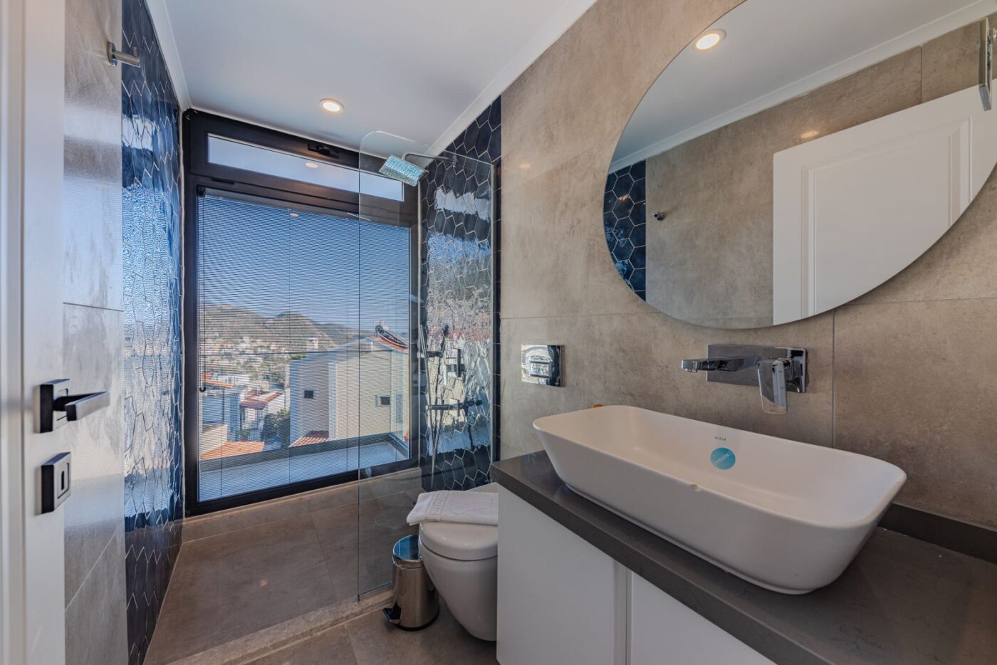 Phòng tắm ngập sáng với cửa sổ lớn và lavabo