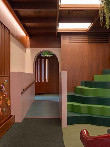 Không gian nội thất gỗ walnut tại Willow Play Cafe ở Toronto với cầu trượt đỏ và khu vui chơi tích hợp cạnh khu cà phê - 5