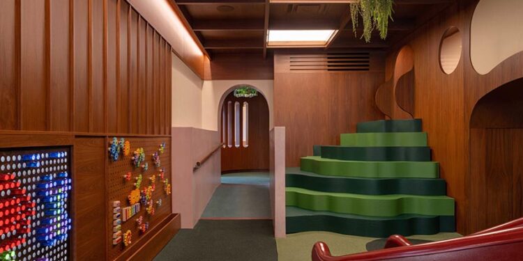 Không gian nội thất gỗ walnut tại Willow Play Cafe ở Toronto với cầu trượt đỏ và khu vui chơi tích hợp cạnh khu cà phê - 5