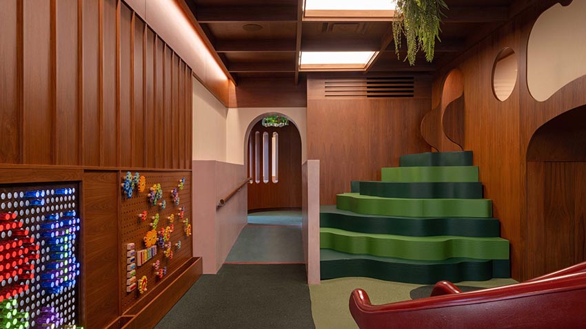 Không gian nội thất gỗ walnut tại Willow Play Cafe ở Toronto với cầu trượt đỏ và khu vui chơi tích hợp cạnh khu cà phê - 5