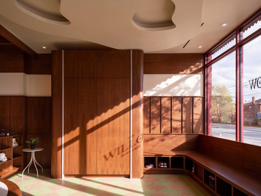 Không gian nội thất gỗ walnut tại Willow Play Cafe ở Toronto với cầu trượt đỏ và khu vui chơi tích hợp cạnh khu cà phê - 4